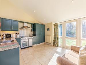 a kitchen with green cabinets and a couch at Wellwood - Uk49290 in Preston +19 photos