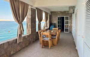 a balcony with a table and chairs and the ocean at Nice Home In Karlobag With Wifi in Karlobag
