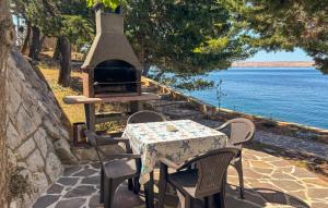 a table and chairs with a grill next to the water at Nice Home In Karlobag With Wifi in Karlobag +21 photos