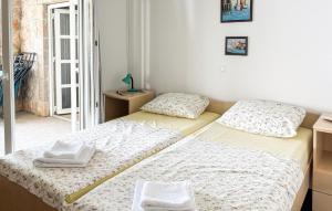 two twin beds in a room with a window at Nice Home In Karlobag With Wifi in Karlobag