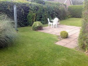 a garden with a bench and a statue of a dog at Clinton Cottage in Yaxham
