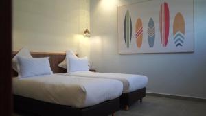 a bedroom with two beds and a picture of surfboards at Surf House Dakhla in Dakhla