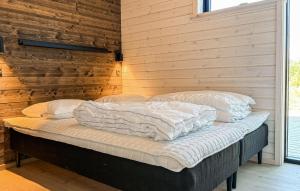a bed in a room with a wooden wall at 3 Bedroom Beautiful Home In Fjerritslev in Fjerritslev
