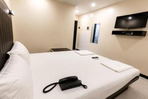 a black phone sitting on a bed in a hotel room at Hotel Taj Palace - Near Mumbai Airport in Mumbai