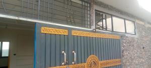 a building with a blue door and some windows at Dreamer Guest house in Nathia Gali