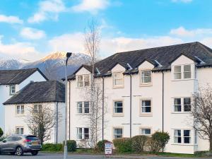 a large white building with mountains in the background at 1 Lonsdale House in Keswick
