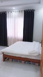 a bed sitting in a room with a window at Dreamer Guest house in Nathia Gali
