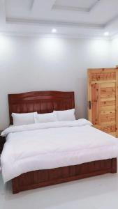 a bedroom with a large bed with a wooden headboard at Dreamer Guest house in Nathia Gali