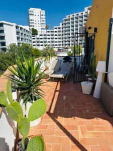 a patio with plants and buildings in the background at Penthouse - Beach - Sea View - Pool - 40 sqm Private Terrace - One Bedroom - Sleeping Alcove in Benalmádena +25 photos
