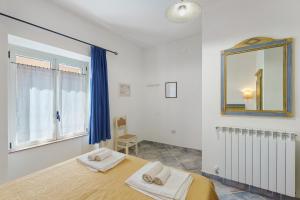 a bedroom with a bed and a mirror at Camera a Dorgali al B&B Sa Madalena in Dorgali