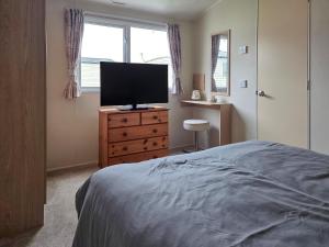 a bedroom with a bed and a television on a dresser at Waterlily in Lancaster +8 photos