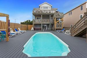 a patio with a swimming pool and a house at 7000 - Serenity Sands in Whalebone