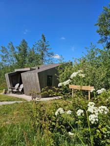 a small house in the middle of a field at Tiny House De Skries in Westergeest