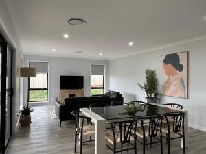 a living room with a table and a couch at Wyoming Ave in North Wagga