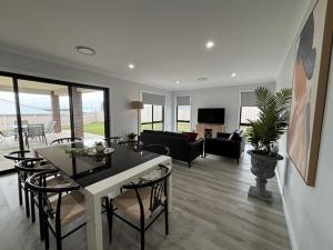 a dining room and living room with a table and chairs at Wyoming Ave in North Wagga