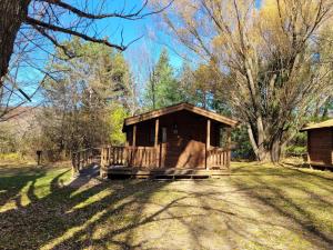 a small woodenshed in a field with a tree at Baraboo RV Resort in Baraboo