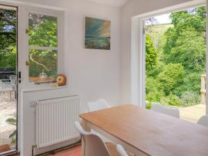 a dining room with a table and chairs and a window at Gara Mill Cottage in Kingsbridge