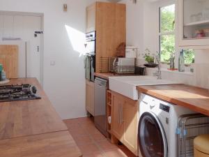 a kitchen with a washing machine and a sink at Gara Mill Cottage in Kingsbridge