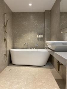 a bathroom with a white tub and a sink at Millennium Hotel in Nashik +55 photos