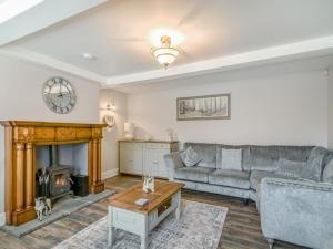 a living room with a couch and a fireplace at The Stirrup Cottage in Blyborough