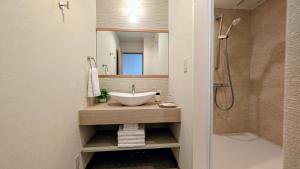 a bathroom with a sink and a shower at Dream Stays HIKARI in Osaka