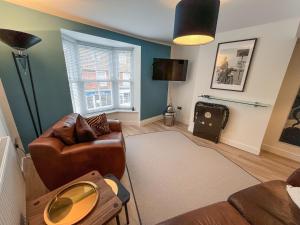 a living room with a couch and a television at Whitstable May House in Whitstable