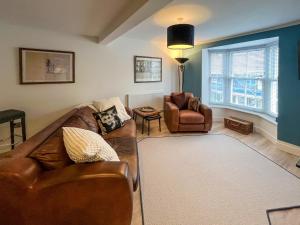 a living room with a couch and a chair at Whitstable May House in Whitstable
