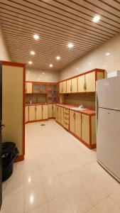 a large kitchen with a refrigerator in a room at شقق رواق in Abha