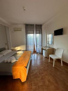 a bedroom with a bed and a desk and a chair at Il Villaggio Hotel Residence Lì Cylentos Elios a 100 mt dal mare cilentomarexperience in Policastro Bussentino