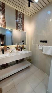 a bathroom with two sinks and a large mirror at شقق رواق in Abha