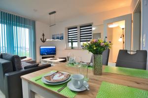 a living room with a table and a couch at Ferienhaushälfte "Ausblick" in Sundhagen-Niederhof