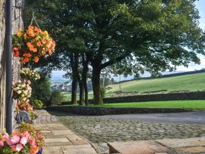 a walkway with flowers on the side of a building at Quarry Cottage in Barnoldswick