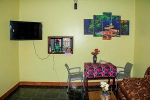 a living room with a table and a television at Tenzi BnB in Jinja