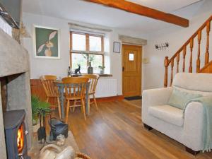 a living room with a fireplace and a table at Quarry Cottage in Barnoldswick