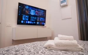 a room with a bed with a tv and towels at Hortus slow room in Montesarchio