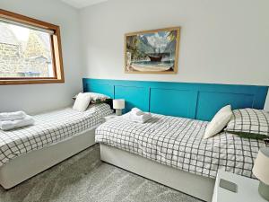 two beds in a room with blue and white at Broadsea Cottage in Fraserburgh +10 photos