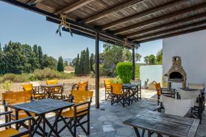 a patio with tables and chairs and a fireplace at Ilios and Irene 5 in Mastihari