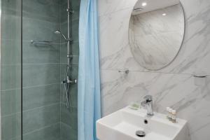 a bathroom with a sink and a shower with a mirror at Ilios and Irene 5 in Mastihari
