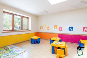 a room with tables and chairs in a classroom at Hotiday Bordighera in Bordighera