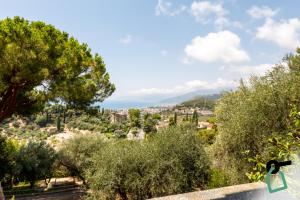 a view of a city from a hill with trees at Hotiday Bordighera in Bordighera