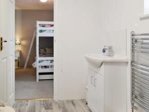 a bathroom with a sink and a bunk bed at Holemoor Cottage in Bridgerule