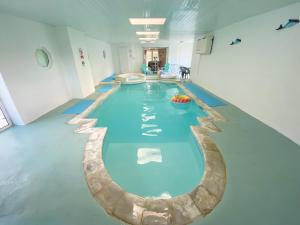 a large swimming pool in a large room with a pool at Holemoor Cottage in Bridgerule