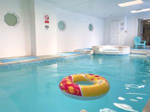 a swimming pool with a raft in the water at Holemoor Cottage in Bridgerule +14 photos