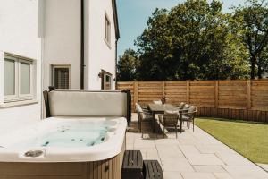 a hot tub on the patio of a house at Upper Oak House in Windermere