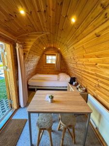 a wooden cabin with a table and a bed in it at UCamp Kemmelberg in Heuvelland