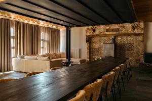 a large wooden table in a living room with chairs at Vakantiewoning - Camping Groenpark in Berlare