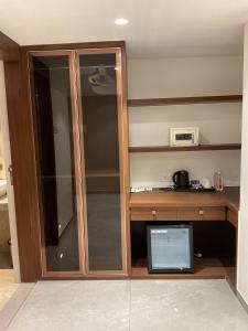 a glass cabinet in a room with a microwave at Millennium Hotel in Nashik