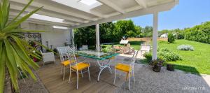 a patio with a glass table and chairs at Domus DEA Holiday Home in Pompei