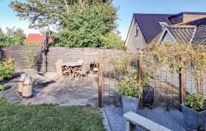 a patio with a table and chairs in a backyard at Stunning Home In Sæby in Sæby