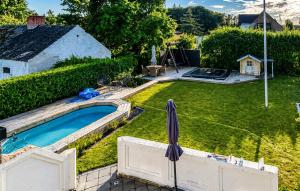 an overhead view of a backyard with a pool and an umbrella at Stunning Home In Sæby in Sæby +12 photos
